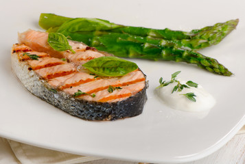 Grilled salmon with asparagus  on white plate