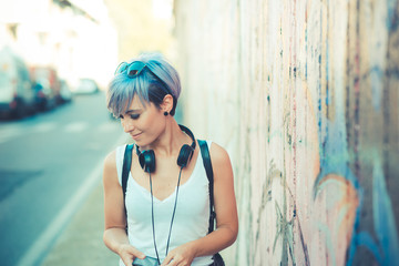 Naklejka premium young beautiful short blue hair hipster woman with headphones mu