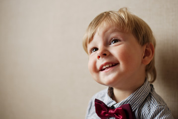 Young Boy Wearing Bow Tie Smiling and Looking Up