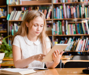 pretty girl with tablet computer working in library