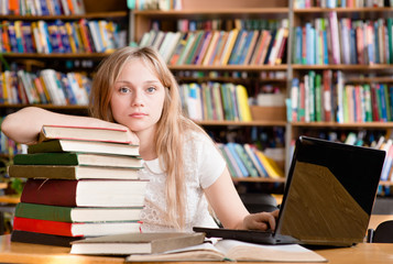 Portrait of a pretty female student in library