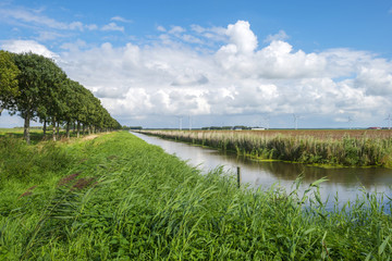 Clouds over a canal through a rural landscape