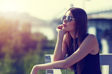 young woman in sunglasses relaxing in sunset