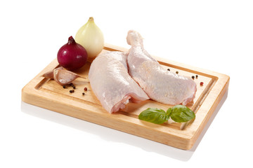 Raw chicken legs on cutting board on white background
