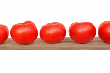Five tomatoes on wooden plank