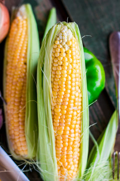 corn on the cob on a green wooden background, closeup