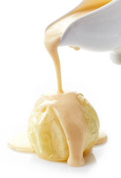 vanilla sauce pouring on baked apple