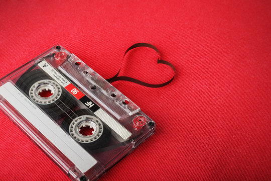 Vintage audio cassette with loose tape shaping a heart