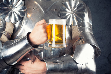 knight wearing armor and holding mug of beer