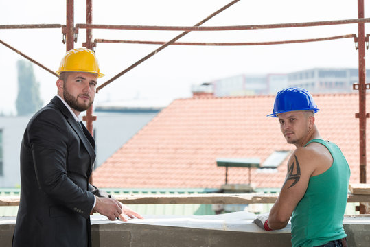 Engineer And Construction Worker Discussing A Project