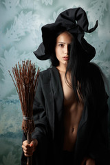 sexy girl in witch costume with a broom