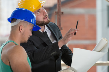 Businessman Showing Industrial Worker At Construction