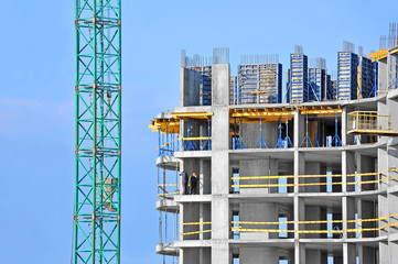 Crane and building construction site against blue sky