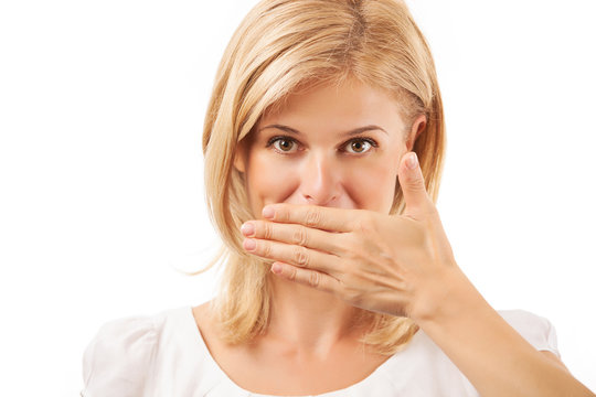 Smiling young woman covering mouth over background