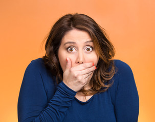 Shocked young woman, covering her mouth stunned 
