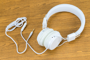 White headphone on wooden background