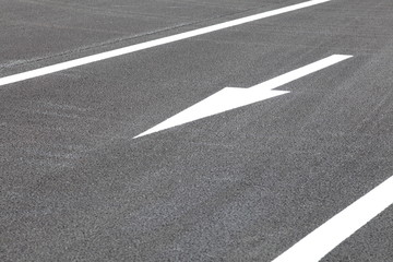 White traffic arrow signage  on an asphalt road