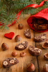 Fototapeta na wymiar Christmas decoration with chocolate biscotti, hazelnuts and pine