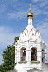 Fototapeta na wymiar White orthodox church against blue sky with white clouds