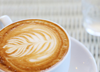 coffee latte art, white coffee cup on table in cafe