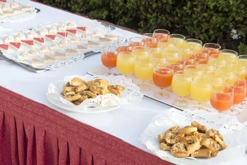Schilderijen op glas Glasses of with exotic drinks and cookies on the decorated table © Piotr Pawinski