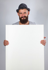 Portrait of young man in hat holding a blank, isolated on white