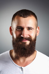 Obraz premium Portrait of handsome bearded man standing, isolated on grey bac