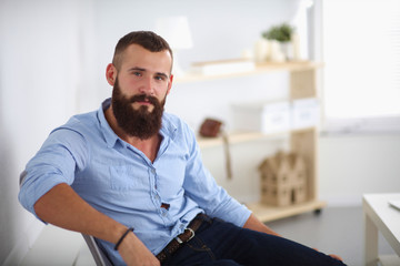 Fototapeta premium Young businessman sitting on chair in office