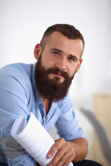 Fototapeta premium Young businessman sitting on chair with book in office