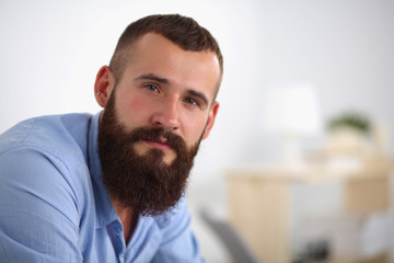 Fototapeta premium Young businessman sitting on chair in office