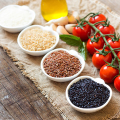 Variety of rice in bowls on wooden table