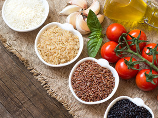 Variety of rice in bowls on wooden table