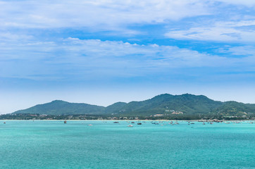 Fototapeta premium boat in a bay with green sea and blue sky (at chalong bay, phuke