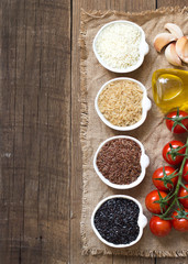 Variety of rice in bowls on wooden table