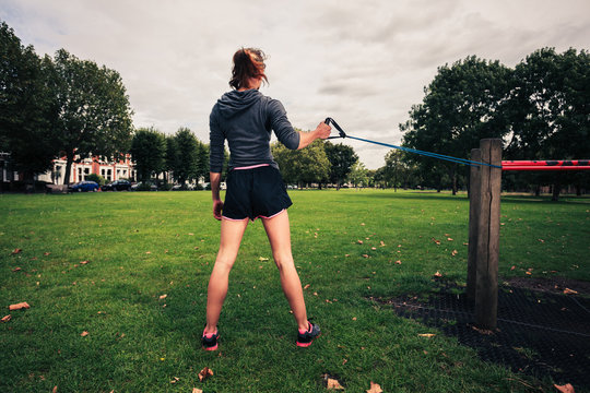 Woman working out with resistance band in the park