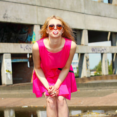 trendy beautiful blonde in a pink dress posing 
