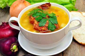 pea soup with smoked pork ribs on a wooden table