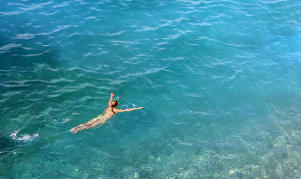 Young Woman Swimming in a Turquoise Water