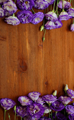 Bouquets of purple eustoma flowers on wooden table, copy-spase