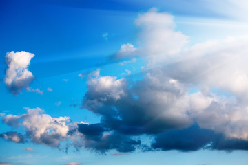 Obraz premium Rozbłysk słońca z białymi chmurami