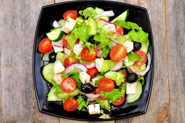 Greek salad (top view) on a wooden table