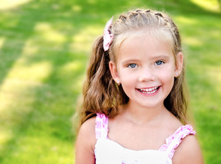 Portrait of adorable smiling little girl in the park
