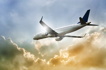 Fototapeta na wymiar Airplane in the dramatic sky and sunbeam