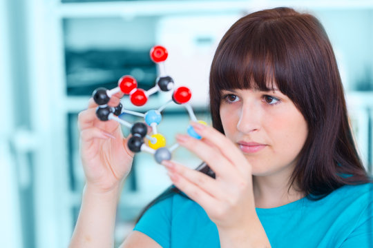 girl student holding a model of chemical molecules - Powered by Adobe