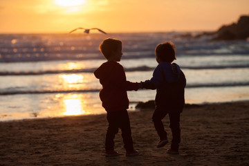 Beautiful picture of two boys on the beach at sunset