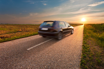 Fototapeta na wymiar Black car in motion blur on open road
