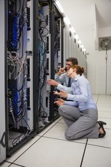 Fototapeta na wymiar Team of technicians kneeling and looking at servers