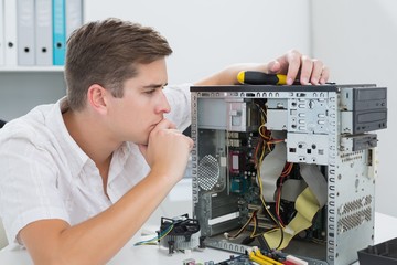 Obraz premium Young technician working on broken computer