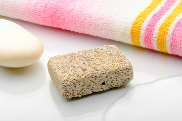 Pumice volcanic stone with pink and yellow towel and white soap