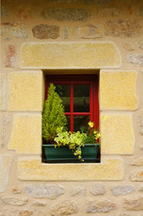 Fototapeta na wymiar Modernes rotes Holzfenster in Natursteinwand aus Granit